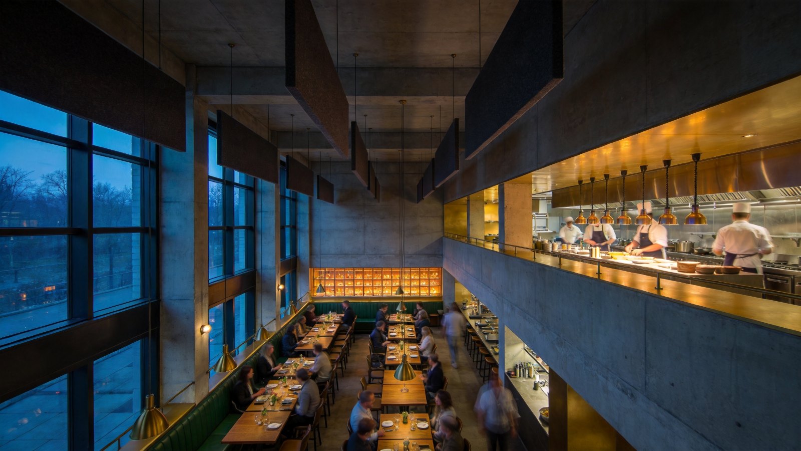 Restaurant with double-height ceiling, open kitchen and acoustic baffles overhead