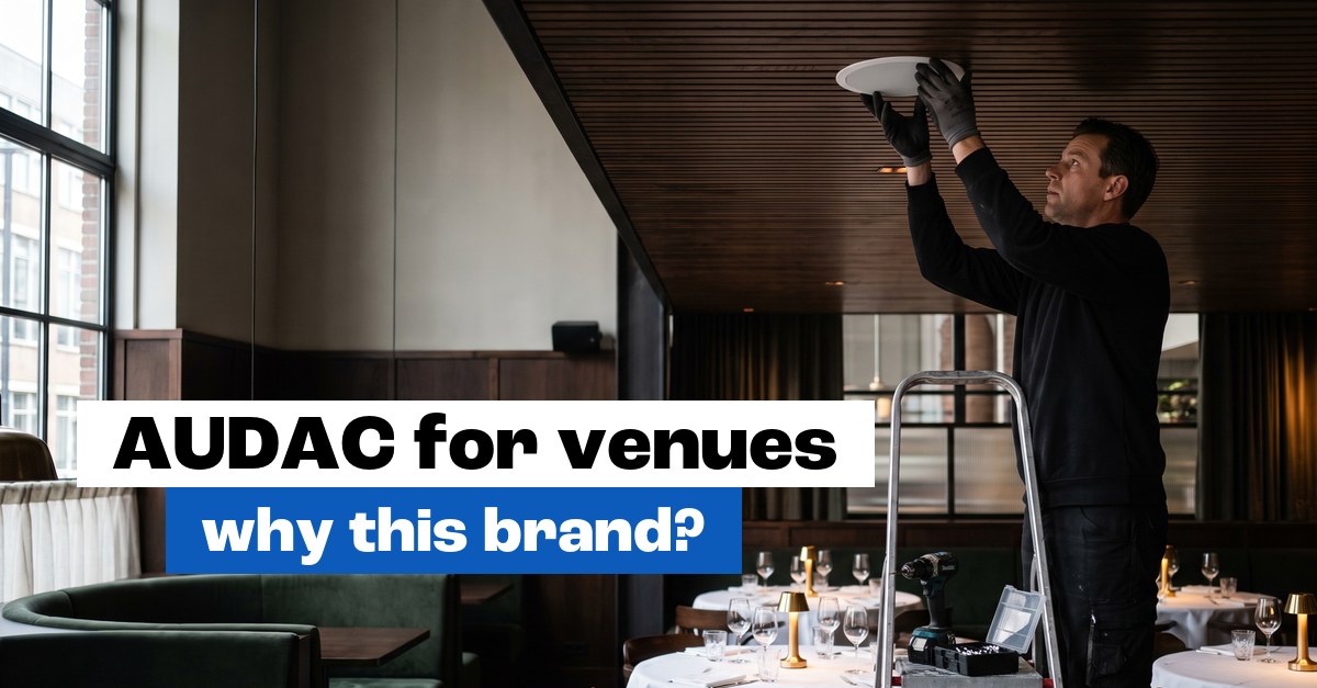Installer fitting a ceiling speaker in a restaurant: AUDAC installation in hospitality