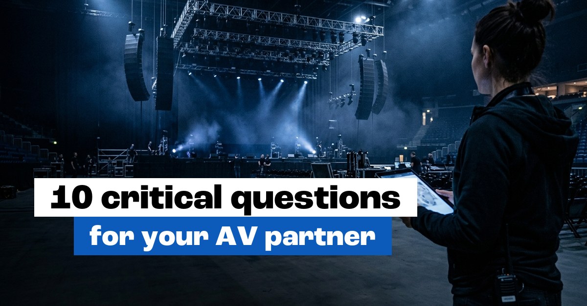 Event planner with a tablet looking at a stage with line array speakers and lighting truss