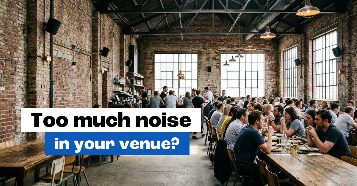 Busy restaurant in an old industrial building with brick walls and wall-mounted speakers
