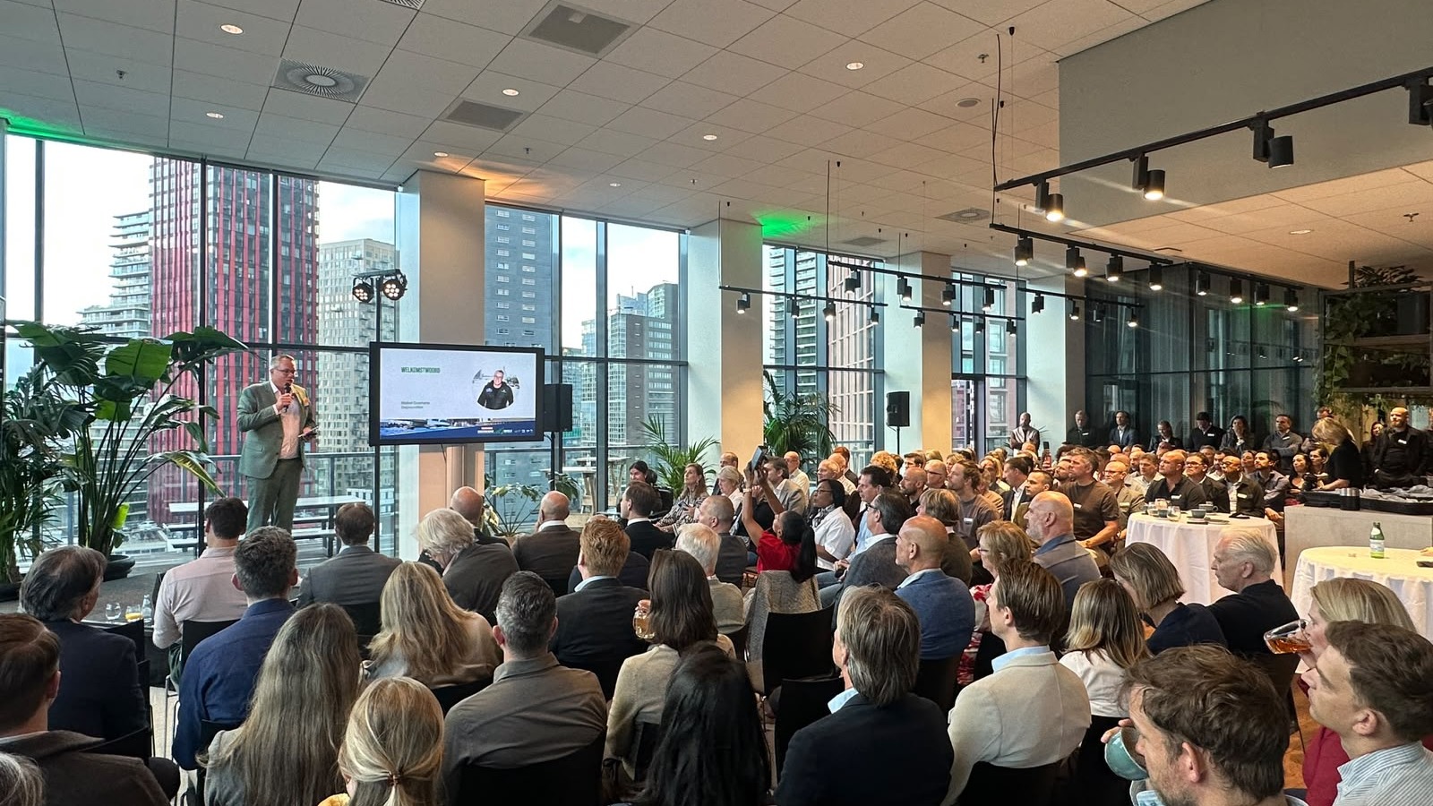 Volle zaal tijdens het Rotterdams Ondernemersontbijt in BLAAK16, spreker voorin naast een scherm
