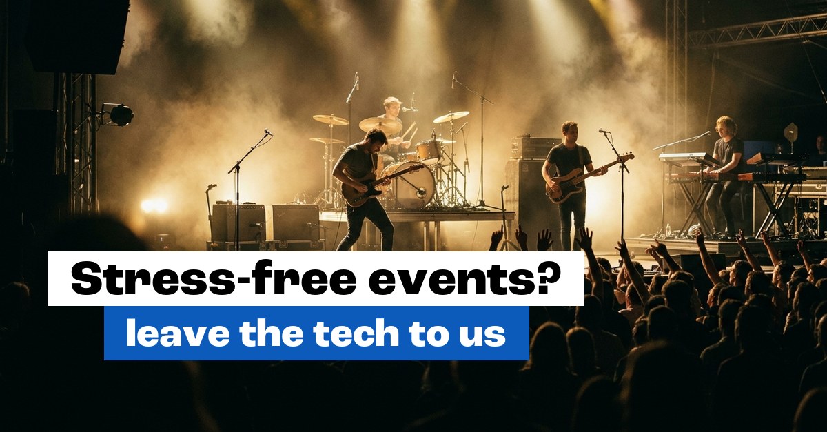 Live band on stage under warm spotlights and haze with the audience in front